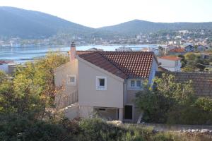 uma casa numa colina com vista para a água em Family friendly house with a swimming pool Vinisce, Trogir - 7510 em Vinišće