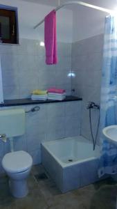 uma casa de banho com um WC, uma banheira e um lavatório. em Family friendly house with a swimming pool Vinisce, Trogir - 7510 em Vinišće