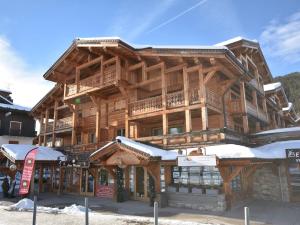 a large wooden building with snow on it at Superbe T6 au centre des Gets - 10 pers, 5 ch, parking, wifi, linge inclus - FR-1-685-7 in Les Gets