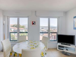 uma sala de jantar com uma mesa e cadeiras e uma televisão em Appartement Saint-Jean-de-Luz, 2 pièces, 4 personnes - FR-1-4-646 em Saint-Jean-de-Luz