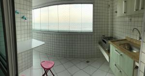 Un baño con un taburete rosa y un lavabo en Apartamento beira mar - Mongaguá, en Mongaguá