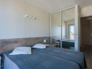 1 dormitorio con cama azul y espejo en Appartement Saint-Jean-de-Luz, 2 pièces, 4 personnes - FR-1-4-655, en San Juan de Luz