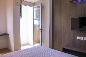 a bedroom with a bed and a sliding glass door at RedLiving Apartemen Gunung Putri Square - Abidin Room Tower Pinus in Parungtandjung