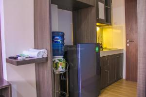 eine kleine Küche mit Kühlschrank und Spüle in der Unterkunft RedLiving Apartemen Gunung Putri Square - Abidin Room Tower Pinus in Parungtandjung