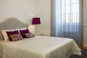 a bedroom with a white bed with two pillows at Casa de Cambres in Lamego