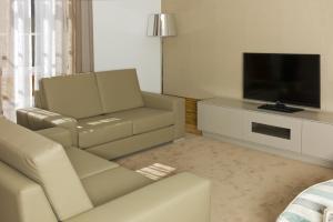 a living room with a couch and a flat screen tv at Casa de Cambres in Lamego