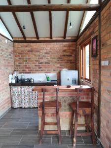 an outdoor kitchen with two chairs and a table at Cabaña lagovilla in Villa de Leyva