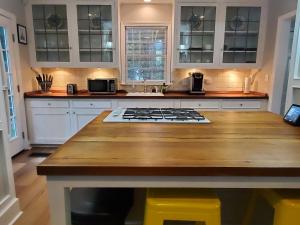 a kitchen with white cabinets and a wooden counter top at Cheerful 2 BR Near Colleges, Downtown, Attractions in Montgomery