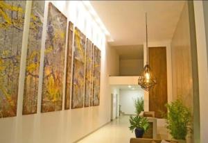 a hallway with a bunch of paintings on the wall at Edificio Atlantis Tower, Confortable y Agradable in Santa Cruz de la Sierra