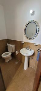 a bathroom with a toilet and a sink and a mirror at Dúplex amplio y luminoso in San Fernando del Valle de Catamarca