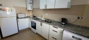 a kitchen with a white refrigerator and a sink at Dúplex amplio y luminoso in San Fernando del Valle de Catamarca