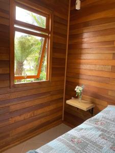 a bedroom with a bed and a window at CHALÉ DOS ALPES VERDES in Canela
