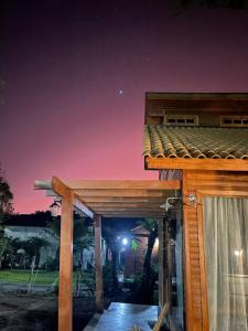 a wooden pergola on a house at night at CHALÉ DOS ALPES VERDES in Canela