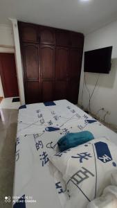 a bedroom with a bed with blue and white sheets at Agradable casa para una excelente estadía. in Palmira