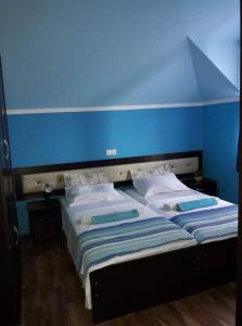 2 camas en una habitación con una pared azul en Sarpi In en Gonio