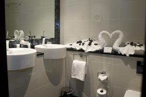 a bathroom with two sinks and a mirror and towels at The Lodge at Kingswood in Epsom