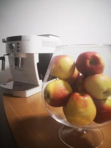 a bowl of apples sitting on a desk next to a computer at Vila Eric in Eforie Sud