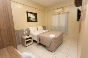 a small bedroom with a bed and a toilet at HOTEL EXECUTIVO in Parauapebas