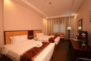 una habitación de hotel con dos camas con un gato sobre ellas en Palawan Uno Hotel en Puerto Princesa