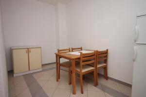 uma cozinha com uma mesa, 2 cadeiras e um frigorífico em Apartments with a parking space Sveti Petar, Biograd - 6174 em Sveti Filip i Jakov