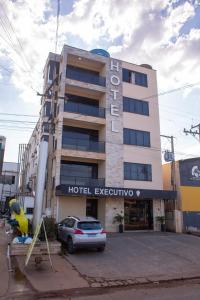 un edificio ejecutivo de hotel con un coche aparcado en un aparcamiento en HOTEL EXECUTIVO, en Parauapebas