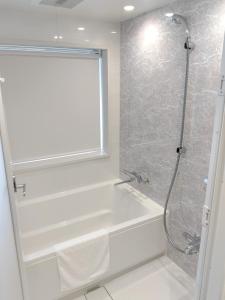 a bathroom with a shower and a white bath tub at ALA HOTEL KYOTO in Kyoto