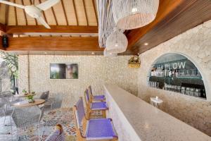 a restaurant with blue chairs and a bar at Puspa Ayu Villas & Apartments in Kuta