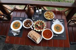einen Tisch mit Schalen Essen und Schalen Suppe in der Unterkunft Qaldea Resort in Uschguli