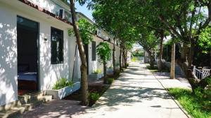 a street in front of a house with trees at Hải An Homestay - Garden by the Beach in Phan Rang