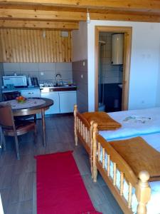 a kitchen and dining room with a bed and a table at Studio apartment Pitomine in Žabljak