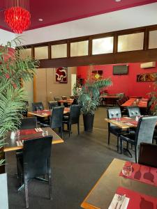 un restaurante con mesas, sillas y paredes rojas en Tranquility at Mandurah Apartments en Mandurah