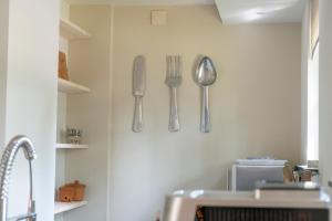 una cocina con utensilios de plata colgados en la pared en Spacious luxury holiday home/villa - Ruime luxe vakantiewoning/-Villa en Ede