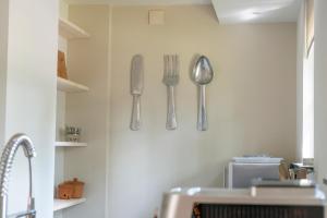 a kitchen with silver utensils hanging on the wall at Spacious luxury holiday home/villa - Ruime luxe vakantiewoning/-Villa in Ede +47 photos