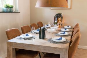 a wooden table with chairs and a dining room at Spacious luxury holiday home/villa - Ruime luxe vakantiewoning/-Villa in Ede