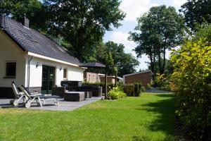 a yard with a patio and a house at Spacious luxury holiday home/villa - Ruime luxe vakantiewoning/-Villa in Ede