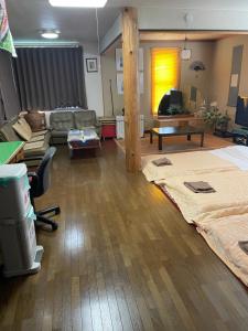 uma sala de estar com uma cama e um sofá em Guest House Chara em Hirosaki