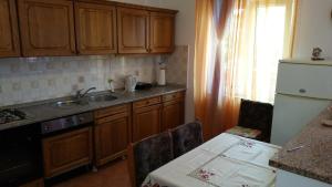 eine Küche mit Holzschränken, einem Tisch und einer Spüle in der Unterkunft Family friendly apartments with a swimming pool Pula - 7610 in Pula