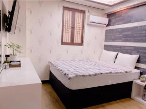 a small bedroom with a bed in a room at Kyoung Dong Hotel Myeongdong in Seoul