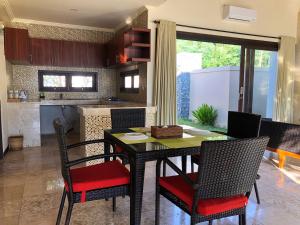 a dining room with a table and chairs in a kitchen at Lombok Sunset Bay Resort in Sekotong