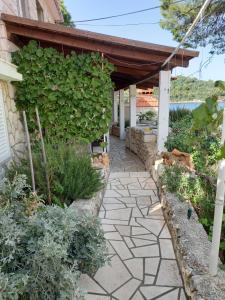 a garden with a stone walkway in front of a building at Apartments by the sea Sobra, Mljet - 7531 in Sobra +32 photos