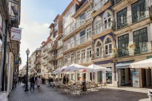 ポルトにあるオポルト　シック&コージー　スタジオ　アパートメントのテーブル・椅子・傘付き通り