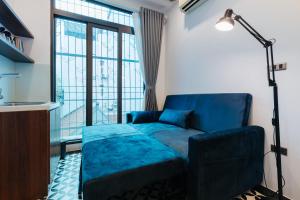 uma sala de estar com um sofá azul e uma janela em Hanoi Old Quarter em Hanói