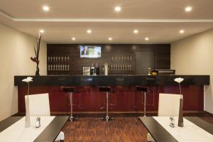 a bar with chairs and a counter in a room at Aparthotel DeLuxe in Oberkochen