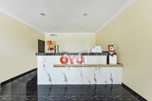 a lobby with a counter with a sign on it at OYO 90445 Th Hotel in Bahau