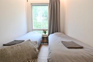 2 Betten in einem Zimmer mit Fenster in der Unterkunft Apartment RIVA in Turku
