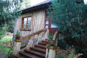 a log cabin with a staircase leading up to it at Boróka Apartmanházak - Öregház in Velem