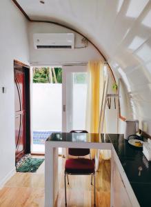 a dining room with a table in a tiny house at Mercy Cottage in Langgur