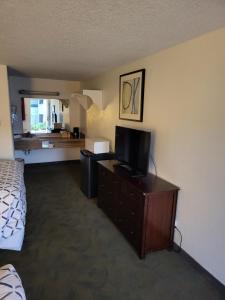 Habitación de hotel con cama y TV de pantalla plana. en Smokey Point Motor Inn en Arlington