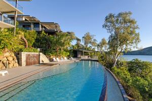 an infinity pool at a house with a view of the water at Shorelines in Hamilton Island