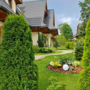 a garden with a hedge in front of a house at Witowiański Dworek in Witów